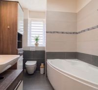 A bathroom with a bathtub and a sink in a 2-room apartment, bright tiles.