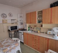 A kitchen in a family house with decorative plates and traditional wooden furniture.