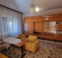 Living room in a family house with retro furniture, armchairs, and curtains.