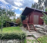 A wooden cabin surrounded by greenery in the Gardens near Ružomberok with stone-clad steps.