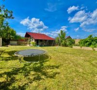 Gardens in Bratislava – Rača at Žabí majer with a trampoline and a gazebo under the blue sky.