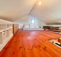 Wooden decor flooring, beds, and storage boxes in the attic.