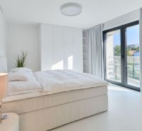 Bright bedroom with a built-in wardrobe, bed, and balcony doors in a 4-room apartment.