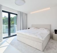 A bedroom with a light bed, curtains, carpet, and a balcony in a 4-room apartment.