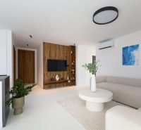 Living room in a 4-room apartment with a wooden decor floor, light seating, and decorations.