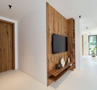 Interior of a 4-room apartment with a TV on the wall and a floor with a wooden decor.