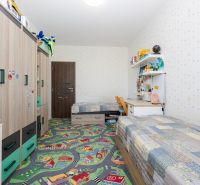 Children's room in a 3-room apartment with a colorful carpet and custom-made furniture.