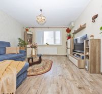 Living room in a 3-room apartment with a blue sofa and a floor with a wood decor.