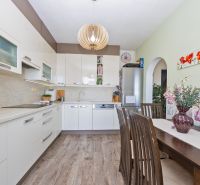 A kitchen in a 3-room apartment with white cabinets and a wood-patterned floor.