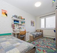 Children's room with two beds in a 3-room apartment, colorful carpet and study desk.