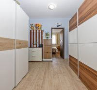 A hallway in a 3-room apartment with built-in wardrobes and a wooden decor floor.