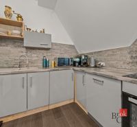 A kitchen in a 4-room apartment with a stone-clad wall and a floor with a wooden decor.