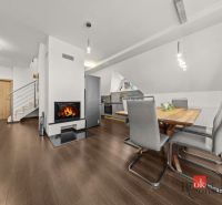 Dining area with a table, chairs, and a fireplace, floor with wood decor.