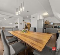 Dining area in a 4-room apartment with wood-patterned flooring and modern lights.