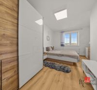 Bedroom in a 4-room apartment with wood-patterned flooring, wardrobe, and bed.