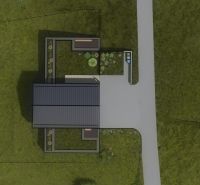 A top view of a family house in Staškov surrounded by grass and a garden.