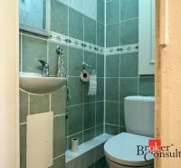 A bathroom with a sink and green tiles in a 3-room apartment.