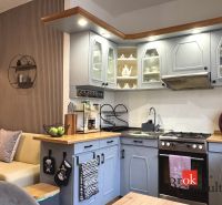 A kitchen in a 3-room apartment with a corner unit and decorative shelves.