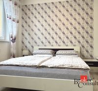 A bedroom in a 3-room apartment with elegant wallpaper and patterned curtains.