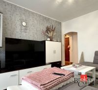 Living room in a 3-room apartment with decorations, a couch, and a television.