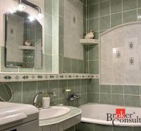 A bathroom in a 3-room apartment with a washing machine, sink, and green tiles.