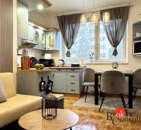 A kitchen in a 3-room apartment with stylish lighting fixtures and a wooden decor floor.