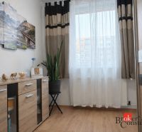 Living room in a 3-room apartment with a wooden decor floor and decorations.