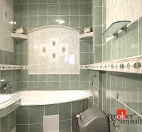 A bathroom with green tiles, a bathtub, and a washing machine in a 3-room apartment.