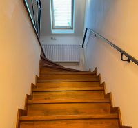 A staircase with wooden decor, a skylight, and a railing in a family house.