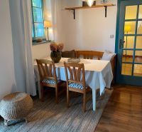 Dining area with wooden furniture and wood-patterned flooring in a family house.