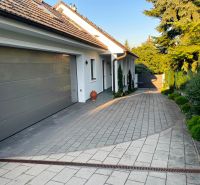 A family house in Bratislava - Dúbravka with a garage, paving, and a well-maintained garden.