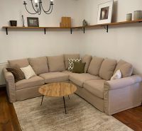 Living room of a family house with a sofa, coffee table, and wooden decor flooring.
