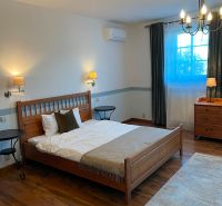 A bedroom in a family house with a comfortable bed and a wooden decor floor.