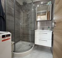 A bathroom with a shower in a 2-room apartment with practical storage space.