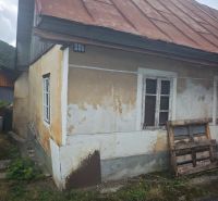 A family house in Špania Dolina with an older facade and a sloped metal roof.