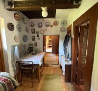 The interior of a cottage with decorative plates on the walls and a floor with a wooden decor.