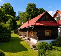 A cottage in Beňadiková with a red roof surrounded by greenery and trees.