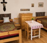 Rustic room in a cottage with patterned beds and wooden furniture.