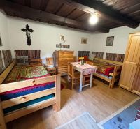 Traditional room in a cottage with beds, wooden furniture, and a floor with a wooden decor.