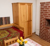 Traditional cottage with a bed, brick fireplace, and wooden furniture.