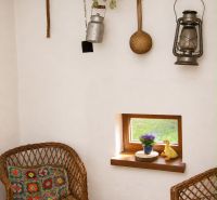 Interior of a cabin with rattan chairs, wood-patterned flooring, and rustic decor.