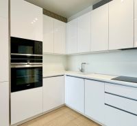 White kitchen with built-in appliances and glossy cabinets in a 2-room apartment.