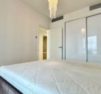A bedroom with a bed, a white wardrobe, and a light fixture in a 2-room apartment.