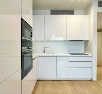 A kitchen with built-in appliances and a wooden decor floor in a 2-room apartment.