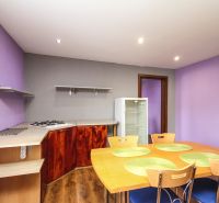 A kitchen in a family house with a wooden decor floor, table, and chairs.
