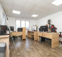 An office with wooden floor decor and work desks in a family house.