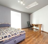 Bedroom with a bed, table, and floor with a wooden decor.