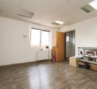 A room in a family house with a wooden decor floor, a shelf, and a radiator.