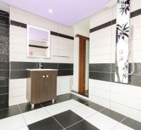 Bathroom in a family house with black and white tiles and minimalist furniture.