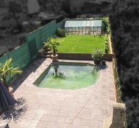 The garden of a family house on Kubranská Street in Trenčín with a swimming pool and a greenhouse.